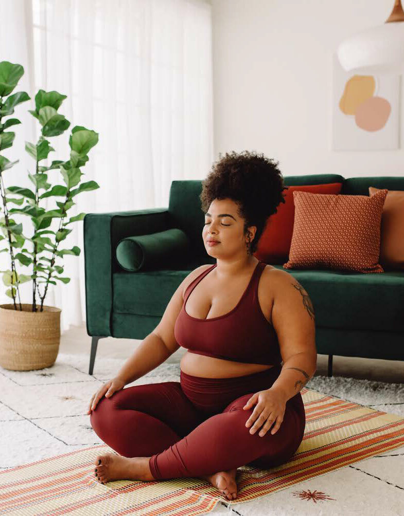 Woman sitting in living room practicing meditation